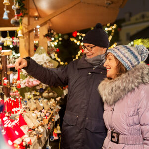 happy senior couple hugging at christmas market